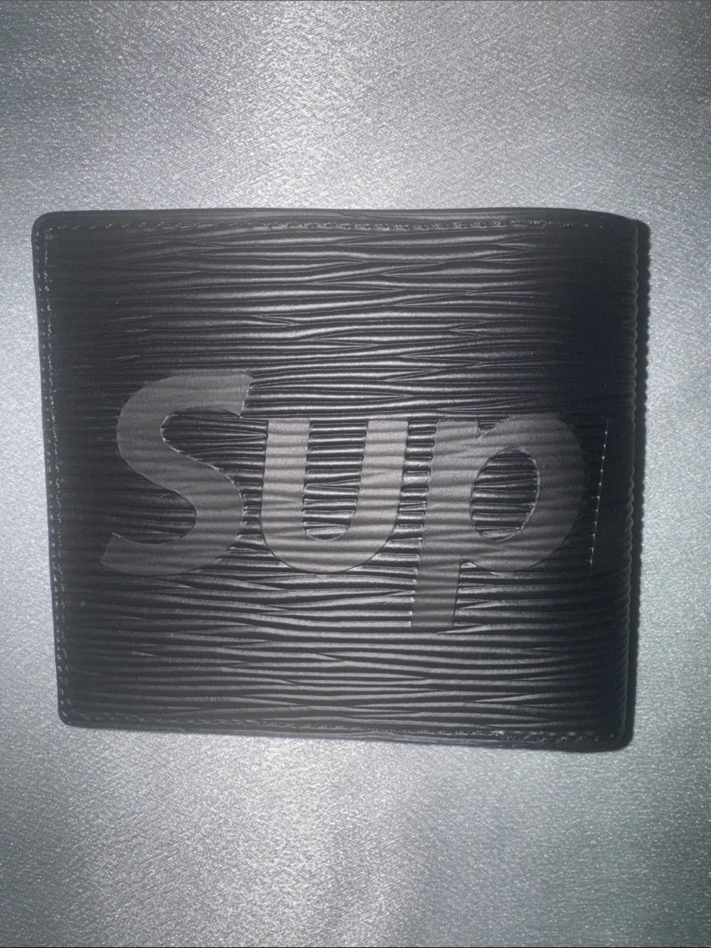 Louis Vuitton x Supreme Epi leather wallet featuring an embossed Supreme logo!